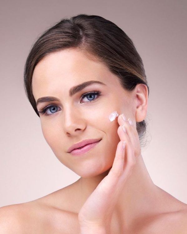 Hands applying cream to a client's skin